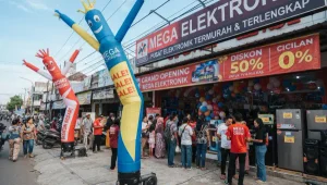 Balon sky dancer berwarna biru dan merah menarik perhatian pengunjung di depan toko elektronik.