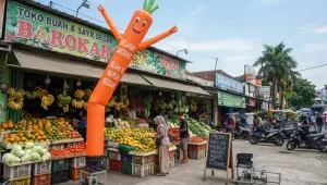Balon sky dancer Lampung berdiri di depan toko buah dan sayur sebagai media promosi usaha.