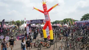 Balon sky dancer padang berwarna merah digunakan untuk memeriahkan acara kontes sepeda.