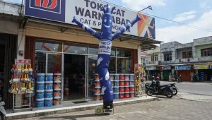 Berdiri di depan toko cat sebagai dekorasi sekaligus media promosi.