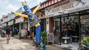 Balon promosi bergerak di depan tempat cukur rambut untuk menarik perhatian pelanggan
