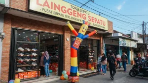 Di depan toko sepatu sebagai media promosi usaha.