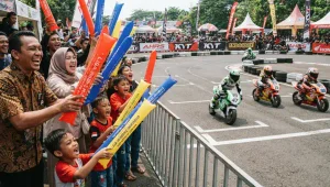 Balon tepuk digunakan penonton untuk memeriahkan perlombaan minibike