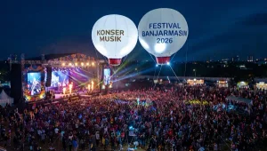 Balon udara promosi berbentuk bulat terlihat di atas keramaian konser musik malam hari