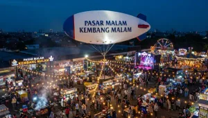 Balon oval bertuliskan Pasar Malam Kembang Malam di tengah keramaian acara