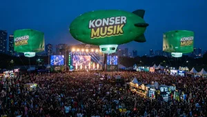 Balon udara promosi Karawang berbentuk balon zeppelin dengan logo sponsor yang menghiasi area konser musik malam hari.