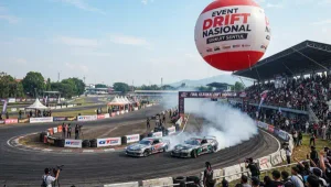 Balon udara promosi berukuran besar terlihat di area acara drift nasional dengan lintasan balap dan tribun penonton.